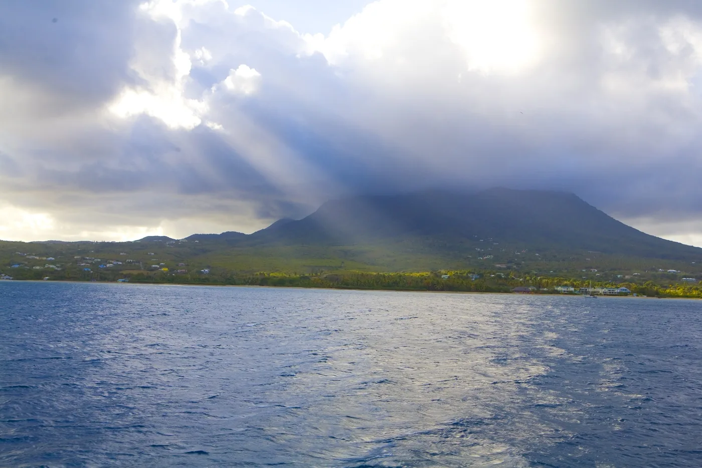 The island of Nevis with its peak under clouds seen across the water