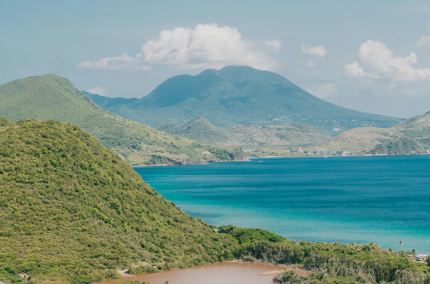 Dry green hills meeting the blue sea on the south of St Kitts